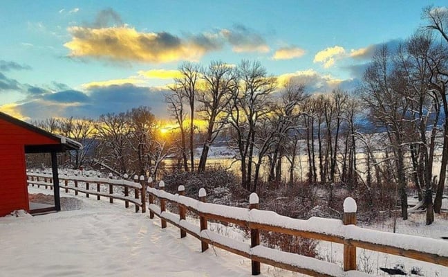Winter sunset over a snow-covered cabin at Glen Eden Resort